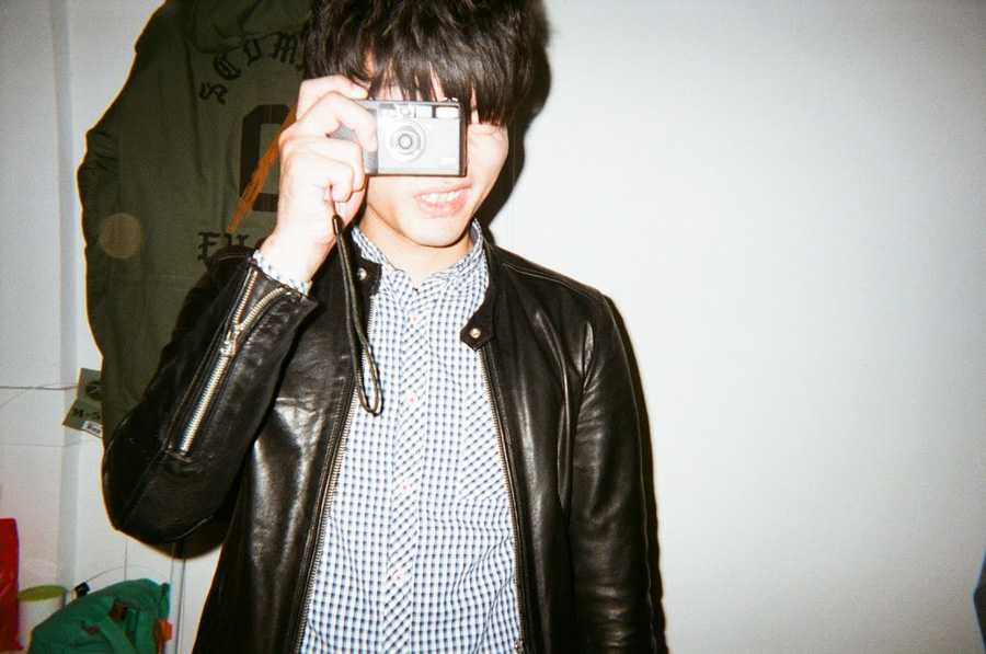 小野友暉がフィルムカメラを構えている。